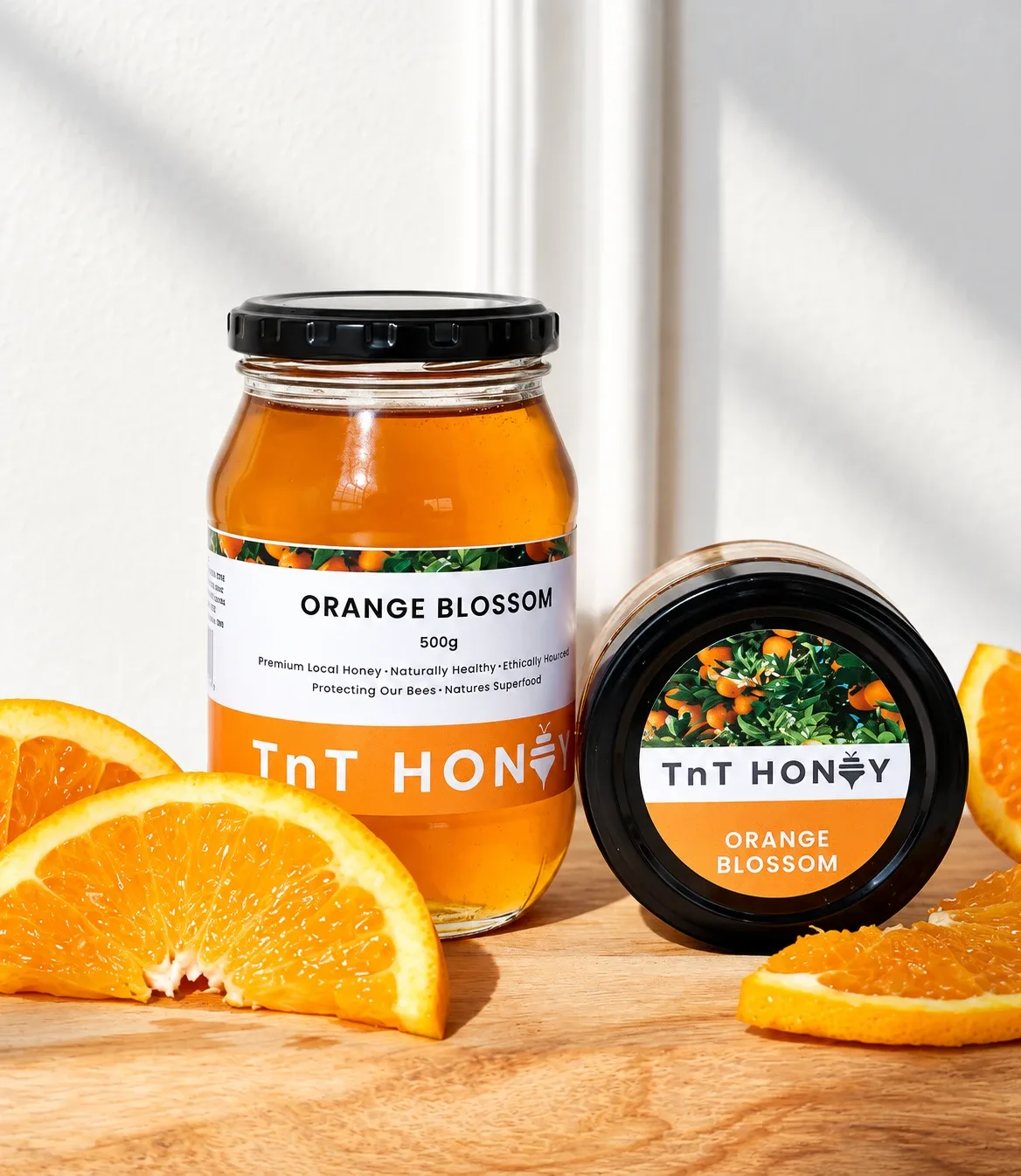 TnT Honey Orange Blossom jar and tub beside fresh orange slices